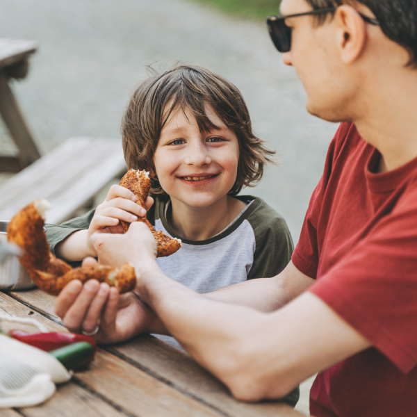 Father And Son Eating Donuts At Picnic Table 600X600